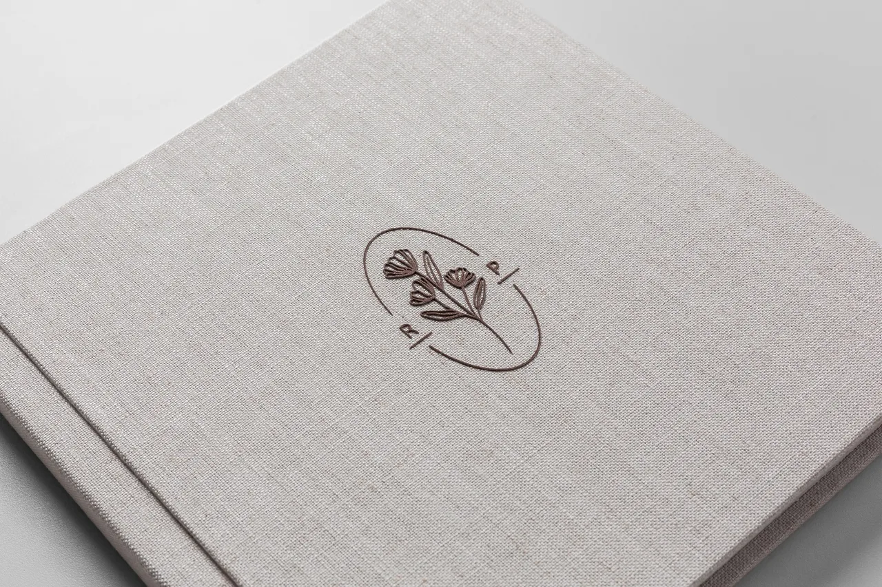 Slim Book com capa de linho cru e brasão gravado